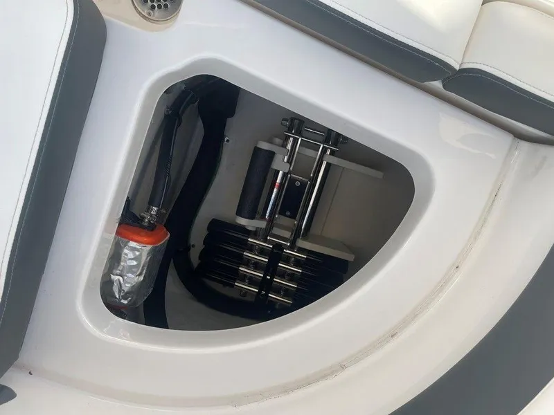 Slide: The Image of 2024 Chaparral 280 OSX boat storage compartment with hydraulic components. - 34