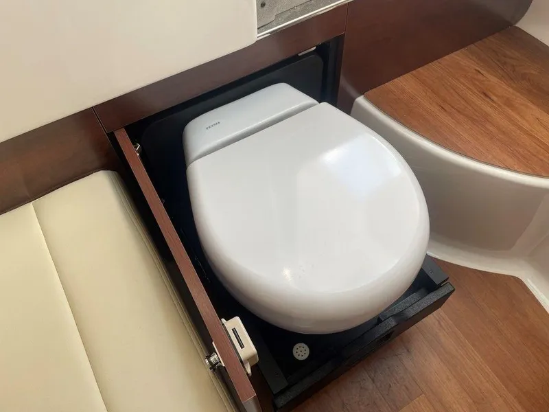 Slide: The Image of 2024 Chaparral 280 OSX boat interior with a compact, modern toilet design. - 43