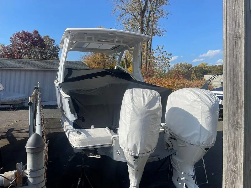 Slide: The Image of 2024 Chaparral 280 OSX boat with covered engines, parked outdoors. - 8