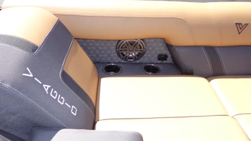 Slide: The Image of 2024 Viaggio Lago Z24U boat interior with tan and black seating, cup holders, and speaker. - 22