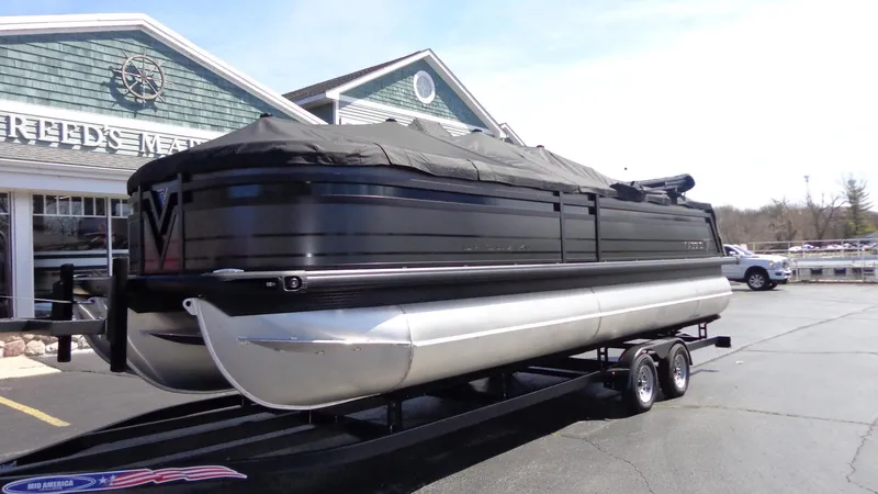 Slide: The Image of 2024 Viaggio Lago Z24U pontoon boat on trailer, covered and parked outside dealership. - 28