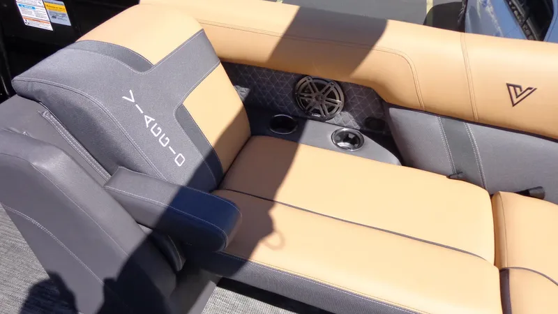 Slide: The Image of 2024 Viaggio Lago Z24U boat interior with tan and gray seating, cup holders, and speaker. - 8