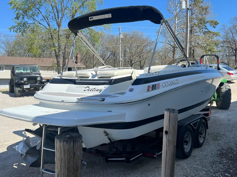 Slide: The Image of 1997 Cobalt 23 boat with canopy on trailer in outdoor setting. - 3