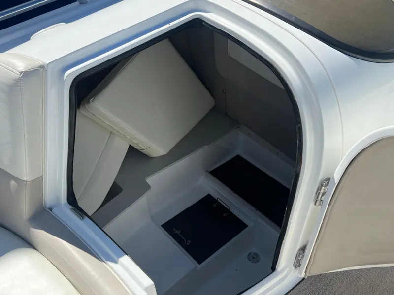 Slide: The Image of Interior storage compartment of a 1997 Cobalt 23 boat with white cushions. - 9