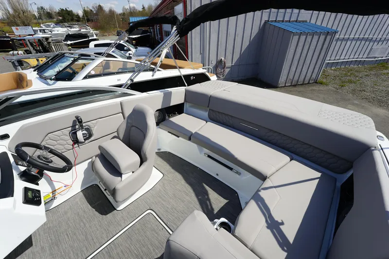 Slide: The Image of 2023 Four Winns H1 boat interior with gray seating and steering console. - 12