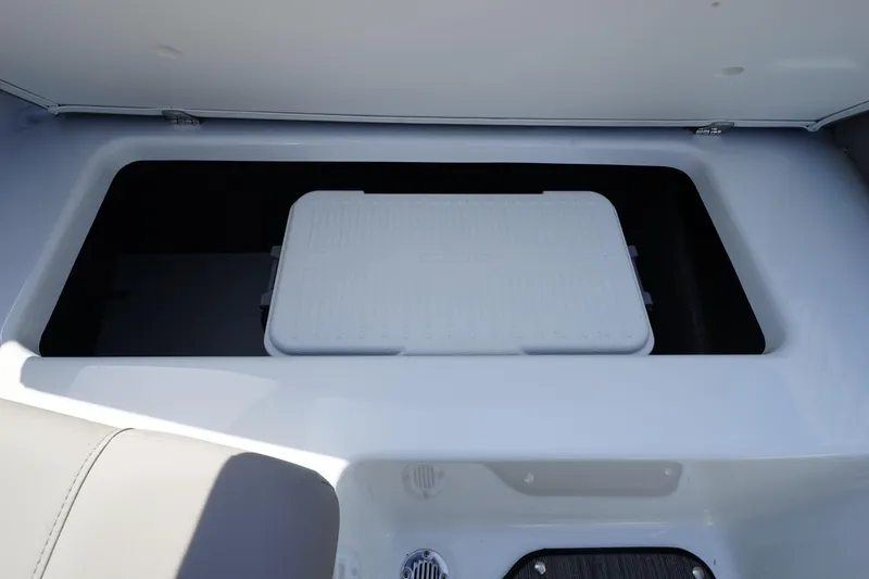 Slide: The Image of 2023 Four Winns H1 boat storage compartment with a white cooler inside. - 16