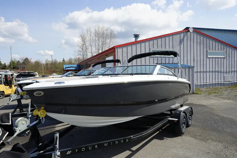 Slide: The Image of 2023 Four Winns H1 boat on a trailer outside a warehouse. - 2