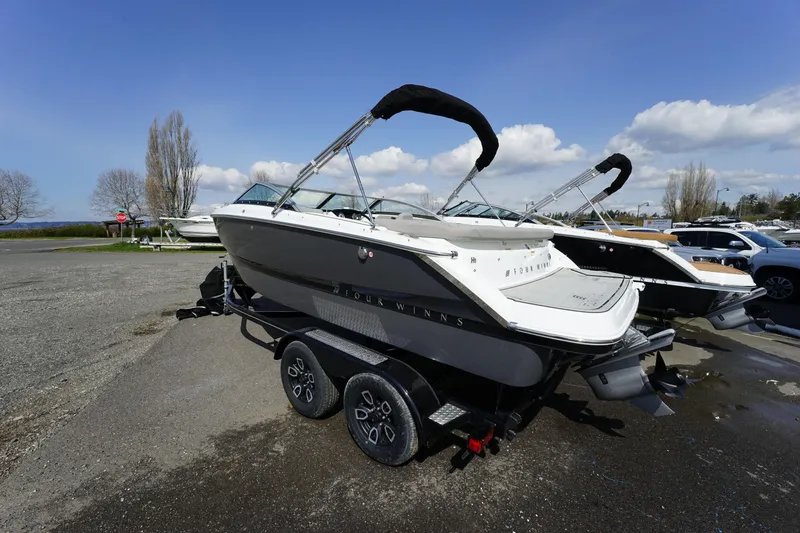 Slide: The Image of 2023 Four Winns H1 boat on a trailer in a parking lot. - 4