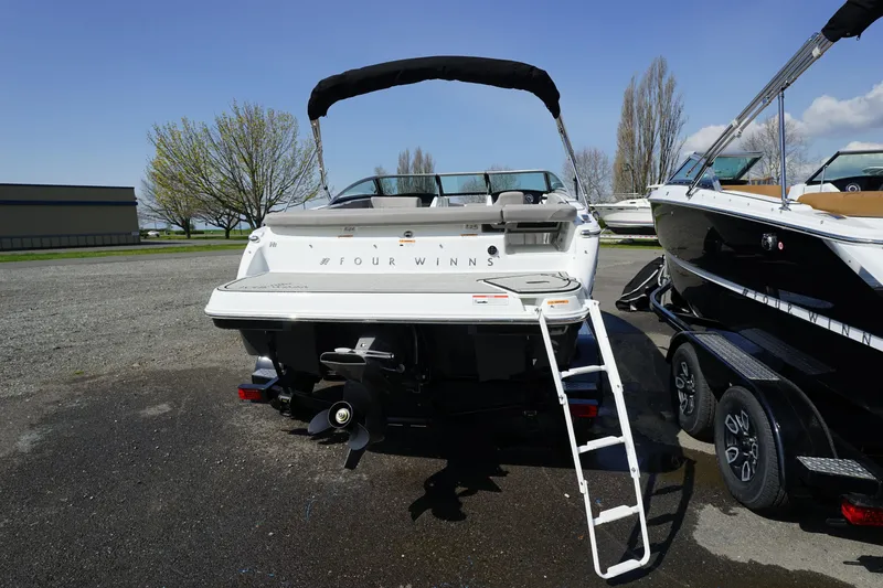 Slide: The Image of 2023 Four Winns H1 boat with ladder and canopy, parked on a trailer. - 7