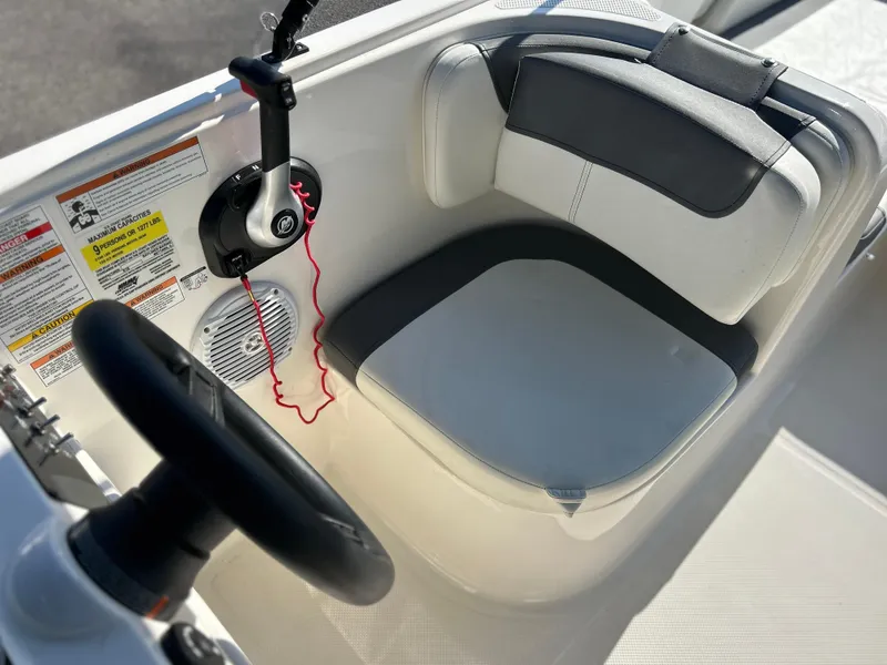 Slide: The Image of 2022 Bayliner Element E18 boat cockpit with steering wheel and cushioned seat. - 12
