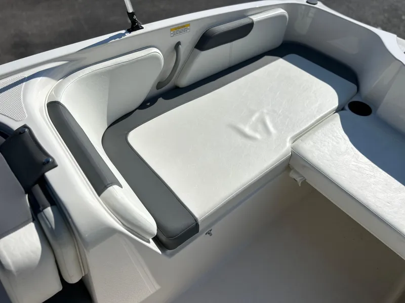 Slide: The Image of 2022 Bayliner Element E18 boat interior seating area with white and gray cushions. - 17