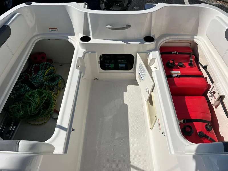 Slide: The Image of 2022 Bayliner Element E18 boat interior with storage compartments and red fuel tanks. - 24