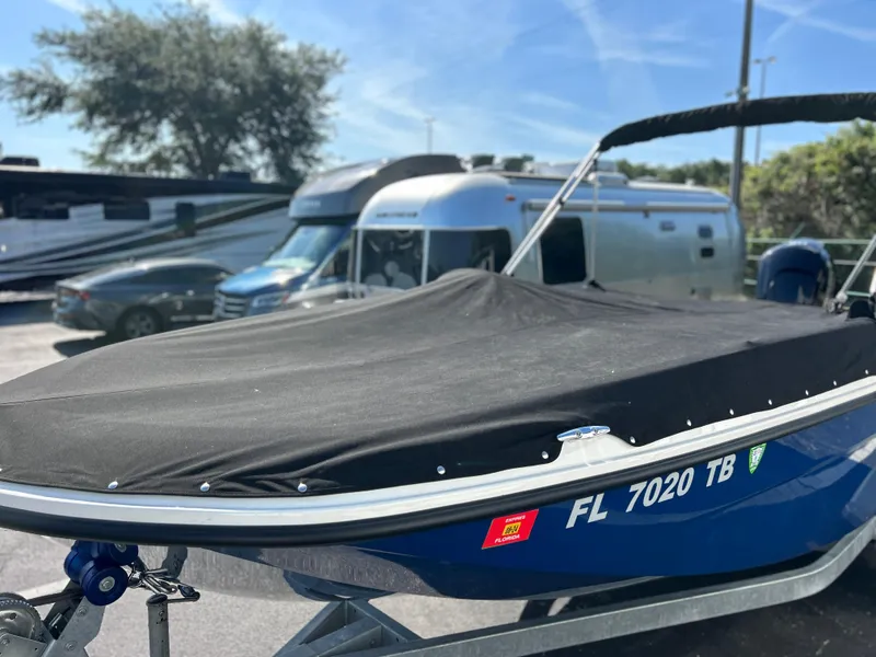 Slide: The Image of 2022 Bayliner Element E18 boat with cover on trailer in parking lot. - 35
