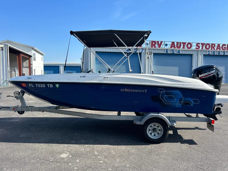 Slide: The Image of 2022 Bayliner Element E18 boat on trailer in front of storage units. - 6