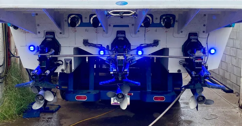 Slide: The Image of 1988 Warlock 37 Cat Cruiser with triple outboard motors and blue LED lights. - 23