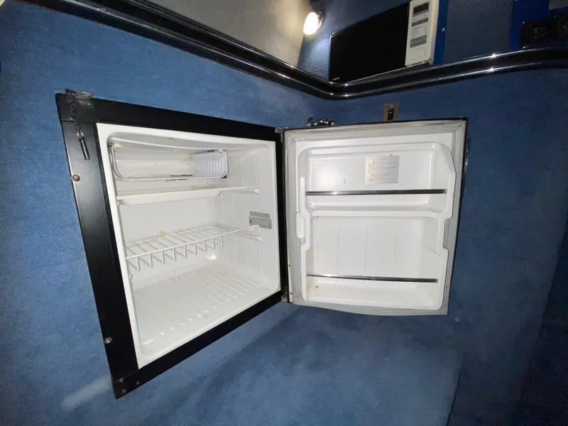 Slide: The Image of Open refrigerator inside a 1988 Warlock 37 Cat Cruiser boat. - 31
