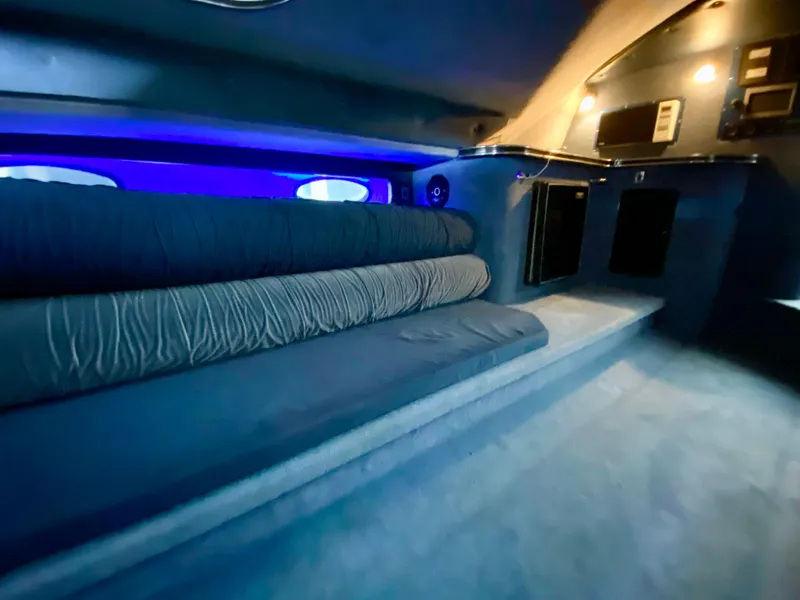 Slide: The Image of Interior of 1988 Warlock 37 Cat Cruiser with blue lighting and cushioned seating. - 32