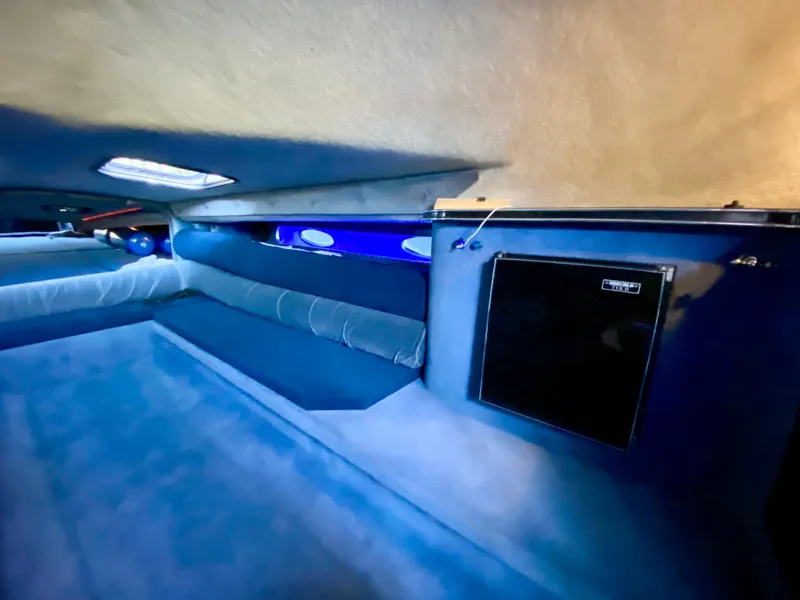 Slide: The Image of Interior cabin of 1988 Warlock 37 Cat Cruiser with blue upholstery and small refrigerator. - 37