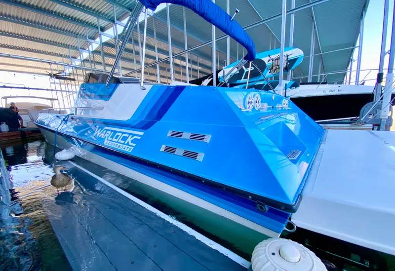 Slide: The Image of 1988 Warlock 37 Cat Cruiser in blue docked at a marina. - 7