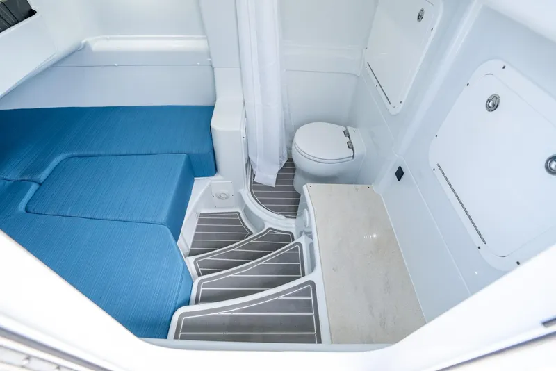 Slide: The Image of 2024 Yellowfin 42 boat interior with blue seating, toilet, and white cabinetry. - 42