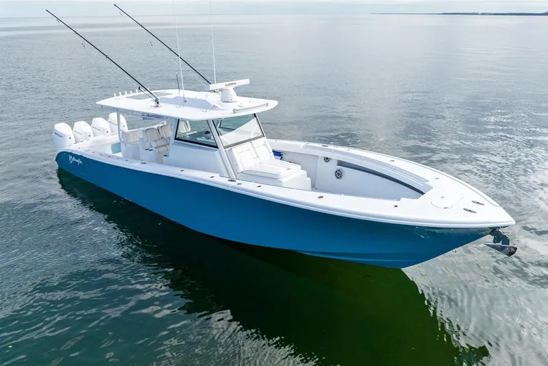 Slide: The Image of 2024 Yellowfin 42 boat on calm water, featuring a sleek blue and white design. - 7