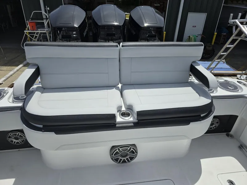 Slide: The Image of 2024 Nor-Tech 452 Super Fish boat with cushioned seating and triple outboard motors. - 17