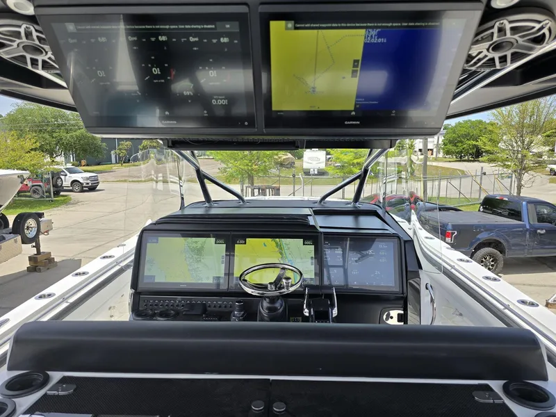 Slide: The Image of 2024 Nor-Tech 452 Super Fish boat dashboard with multiple navigation screens and controls. - 21
