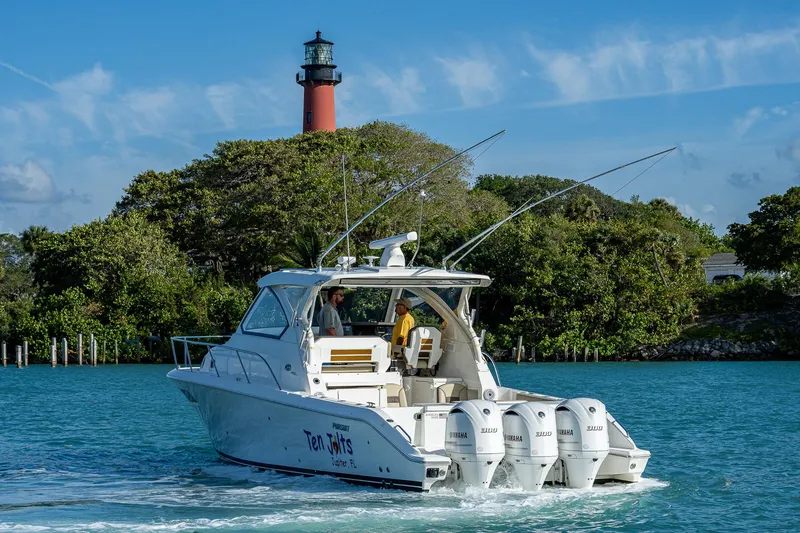 Slide: The Image of 2020 Pursuit OS 355 boat cruising near a lighthouse. - 11