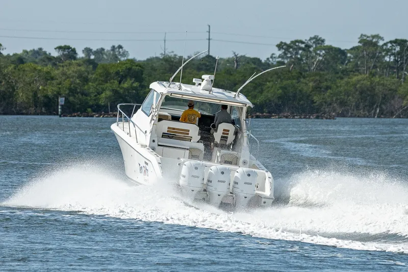 Slide: The Image of 2020 Pursuit OS 355 boat cruising on a lake with two people onboard. - 19