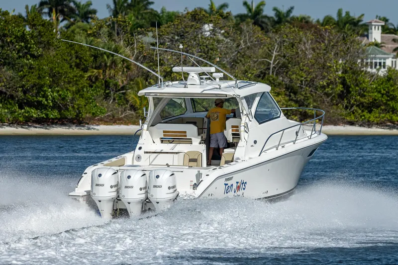 Slide: The Image of 2020 Pursuit OS 355 boat cruising on water with triple outboard engines. - 22