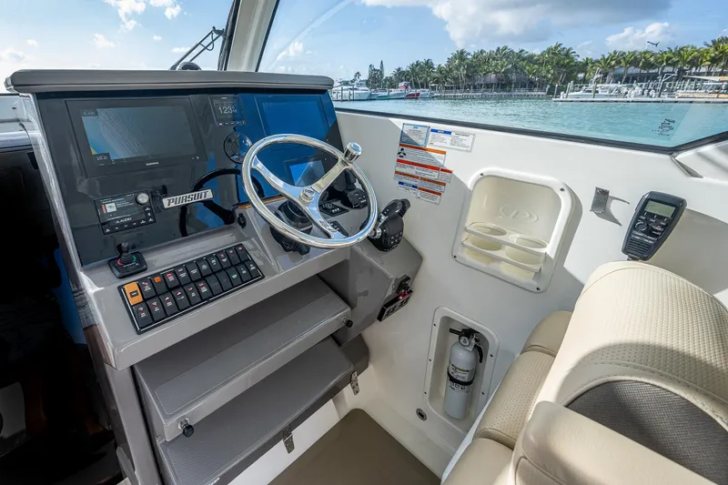 Slide: The Image of 2020 Pursuit OS 355 boat helm with steering wheel, control panel, and ocean view. - 25