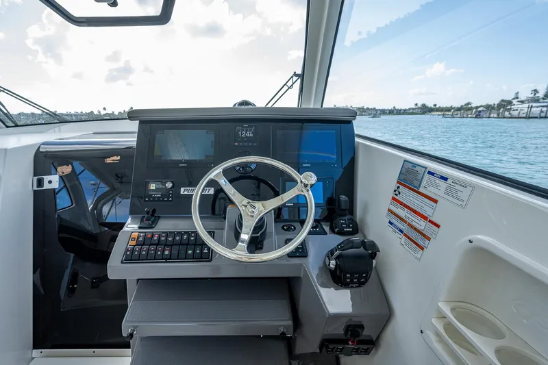 Slide: The Image of Helm of 2020 Pursuit OS 355 boat with steering wheel and control panel. - 28