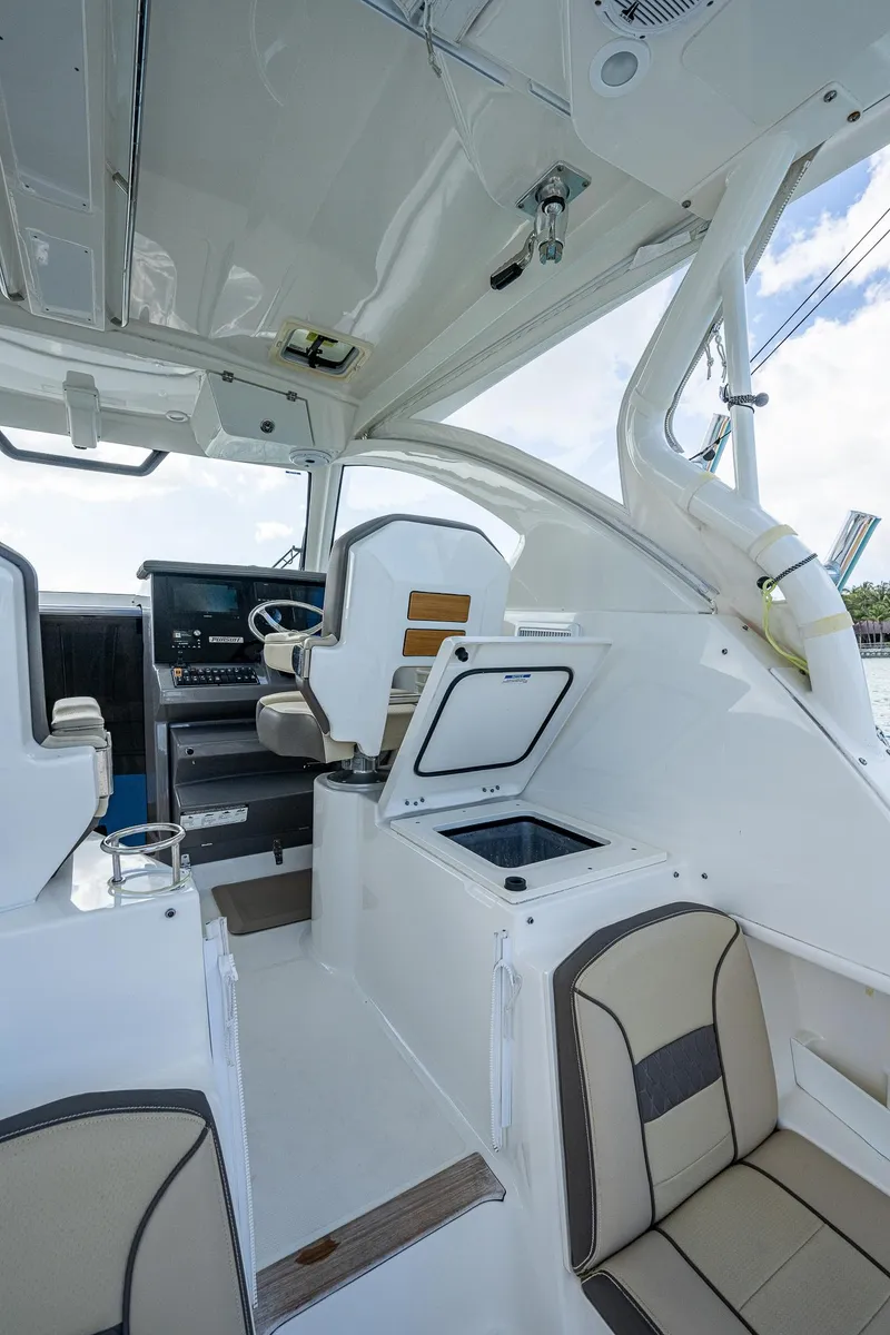 Slide: The Image of 2020 Pursuit OS 355 boat interior with helm, seating, and storage compartments. - 32