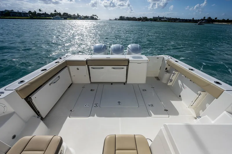 Slide: The Image of 2020 Pursuit OS 355 boat deck with triple outboard engines on the water. - 35