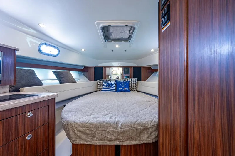 Slide: The Image of 2020 Pursuit OS 355 cabin interior with round bed and wooden cabinetry. - 42