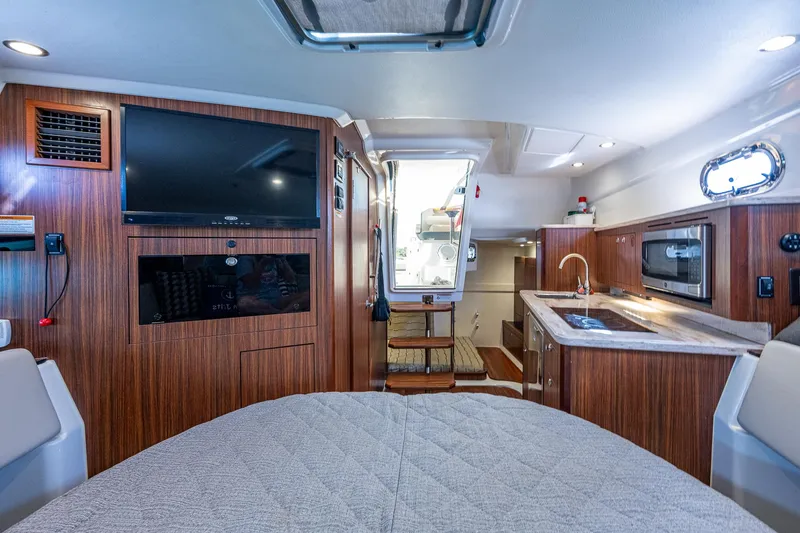 Slide: The Image of Interior of 2020 Pursuit OS 355 boat with modern amenities and wood finish. - 44