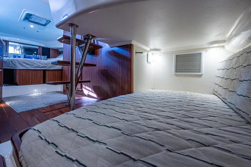 Slide: The Image of Interior cabin of 2020 Pursuit OS 355 boat with cozy bedding and wooden accents. - 49
