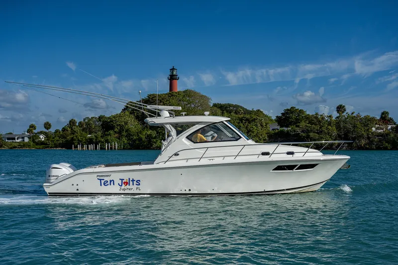 Slide: The Image of 2020 Pursuit OS 355 boat cruising on a sunny day near a lighthouse. - 5