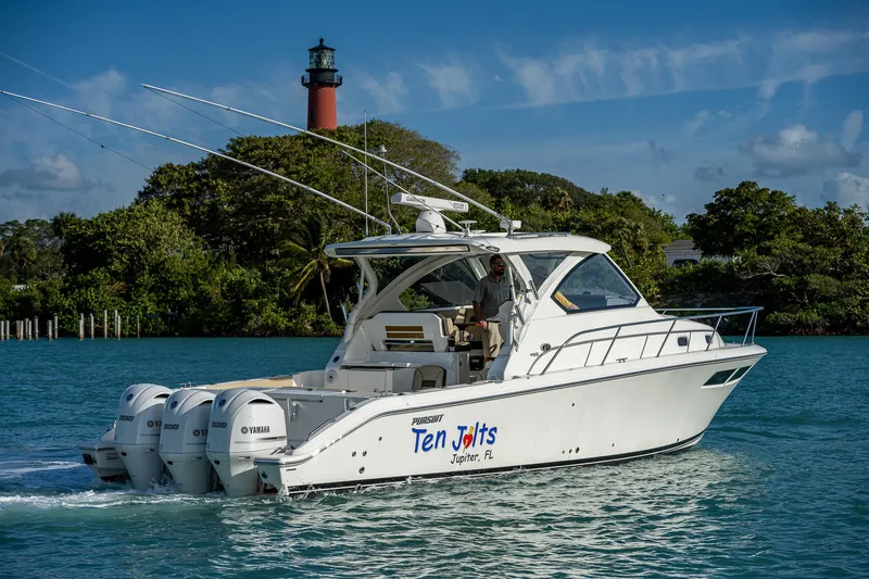 Slide: The Image of 2020 Pursuit OS 355 boat cruising near a lighthouse. - 8