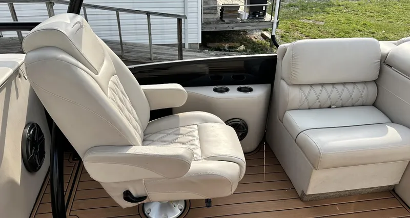 Slide: The Image of 2014 Bennington 2550 QSR boat interior with beige seating and cup holders. - 16