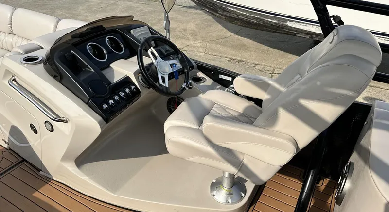 Slide: The Image of 2014 Bennington 2550 QSR boat helm with beige captain's chair and control panel. - 17