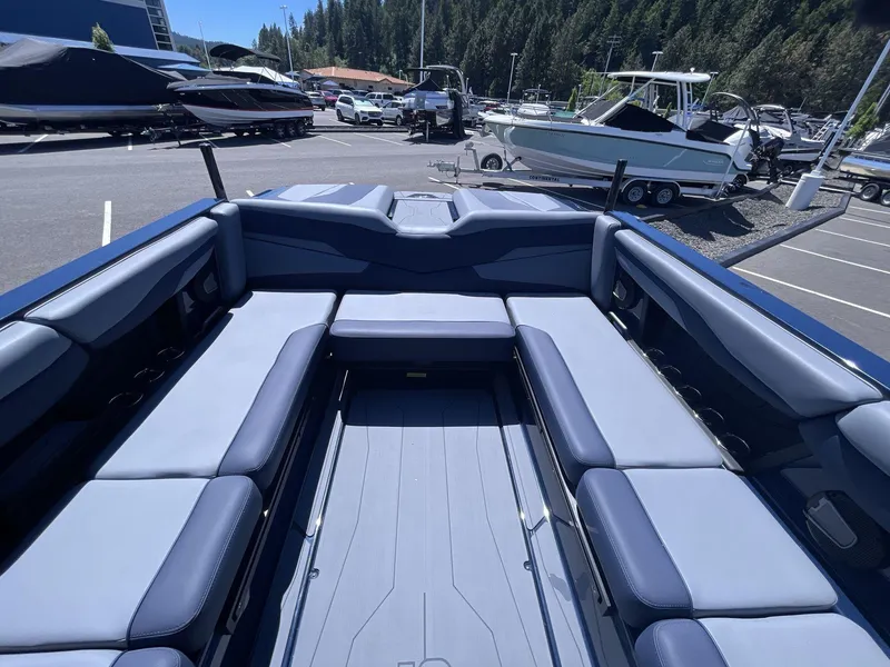Slide: The Image of 2024 Axis T250 boat interior with spacious seating, parked in a marina. - 16