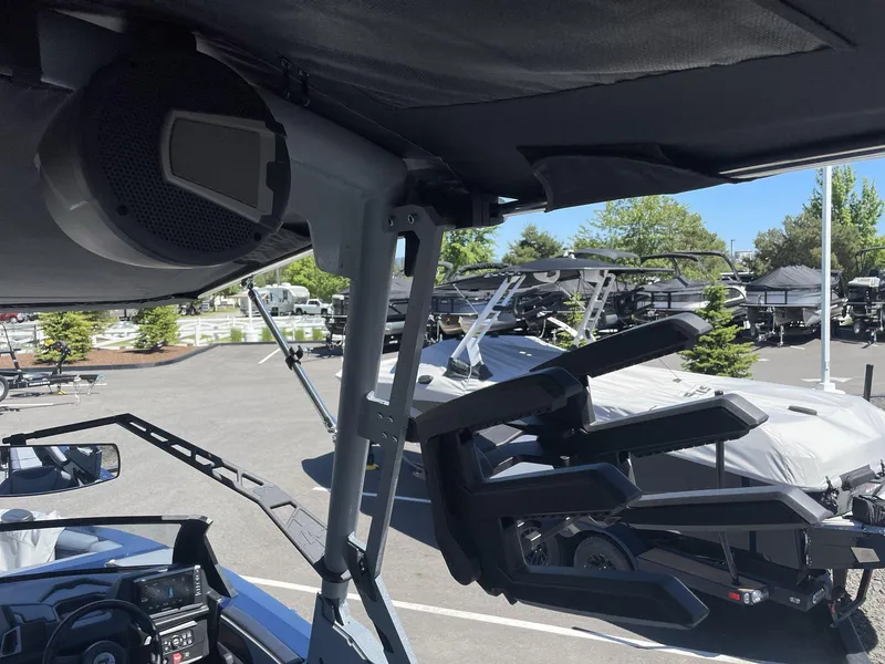 Slide: The Image of 2024 Axis T250 boat interior with speaker and wakeboard rack in a dealership lot. - 18