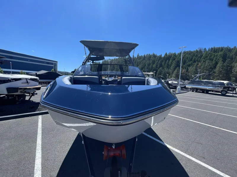 Slide: The Image of 2024 Axis T250 boat in parking lot, surrounded by trees and clear blue sky. - 4