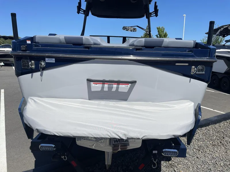 Slide: The Image of 2024 Axis T250 boat rear view in a parking lot, showcasing sleek design and covered propeller. - 7