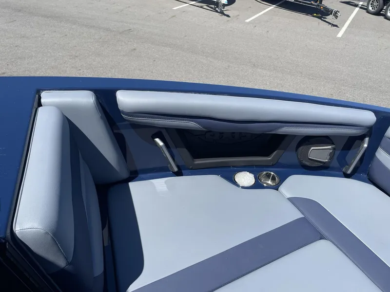 Slide: The Image of 2024 Axis T250 boat interior with blue and gray seating, cup holders, and speaker. - 9