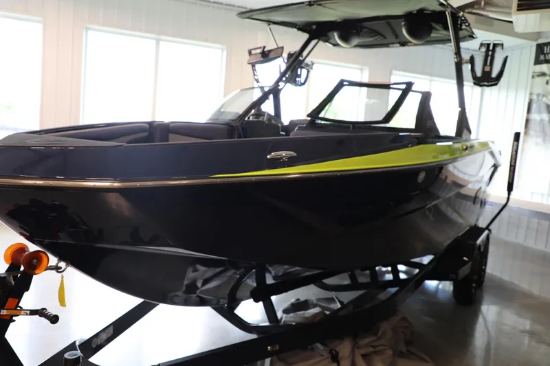 Slide: The Image of 2024 Axis T250 boat in showroom, sleek design with black and green accents. - 4
