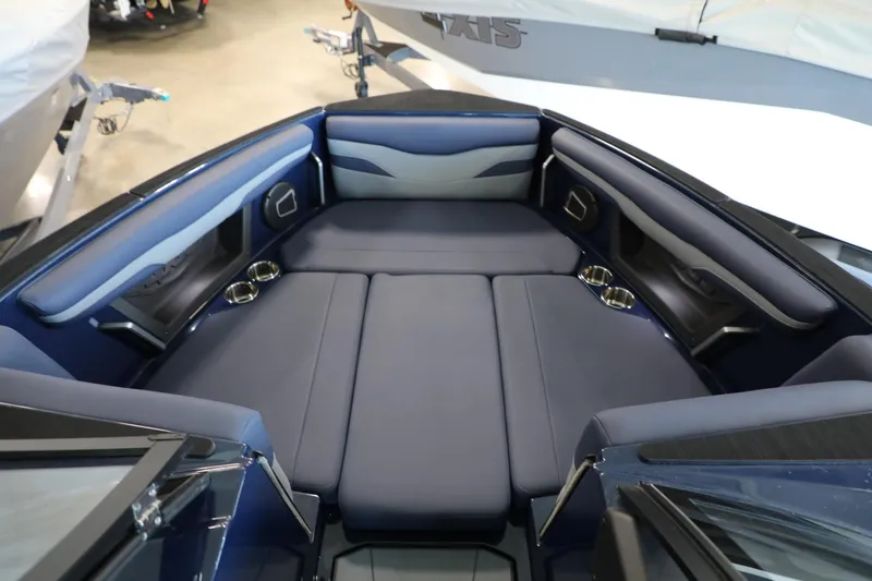 Slide: The Image of 2024 Axis T250 boat interior with blue cushioned seating and cup holders. - 9