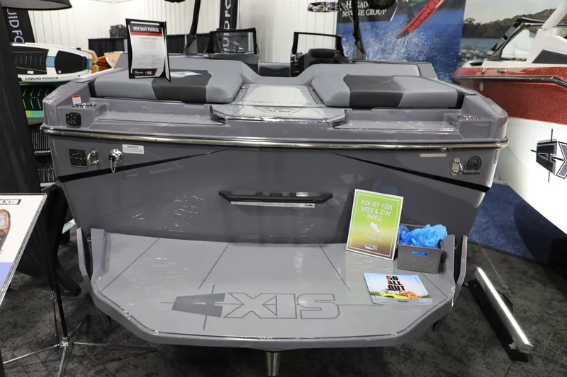 Slide: The Image of 2024 Axis T250 boat display with gray seating and promotional materials at a boat show. - 7