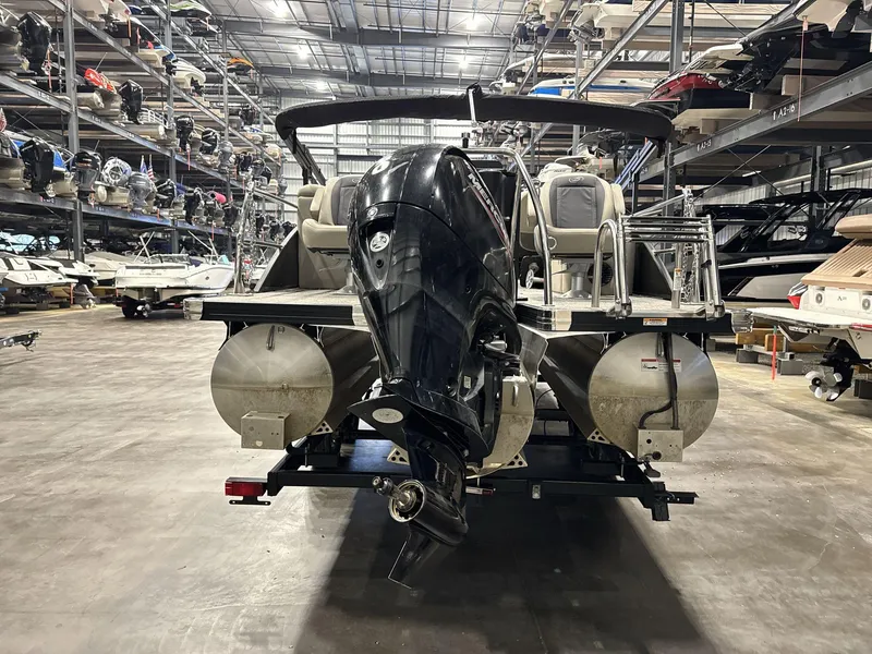 Slide: The Image of 2023 Barletta C24CC pontoon boat in storage facility, rear view with outboard motor. - 6